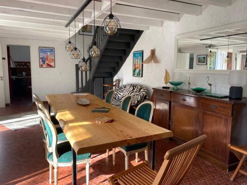 une salle à manger avec une table et des chaises en bois dans l'établissement Maison Saint Roch, à Mouchan