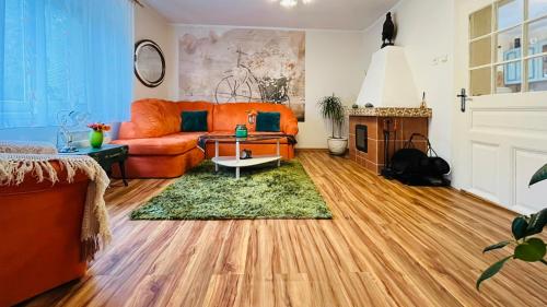 a living room with an orange couch and a table at Bačalandia- relax na samote in Veľká Dolina
