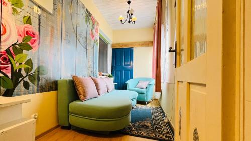 a living room with a green couch and a chair at Bačalandia- relax na samote in Veľká Dolina
