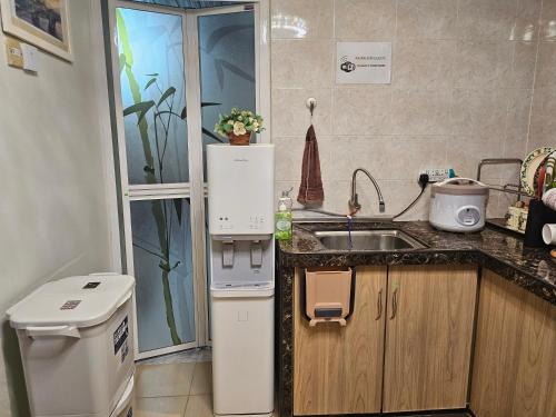 a small kitchen with a sink and a refrigerator at SMART Homestay Permaipura in Sungai Petani