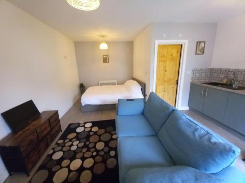 a living room with a blue couch and a bed at Jim's place in Bristol