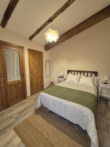 a bedroom with a large bed and a chandelier at Casa Rural Rincón in El Cabaco