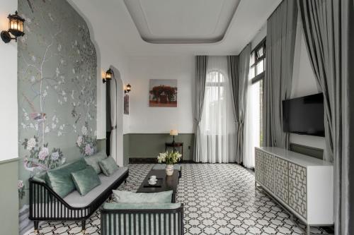 a living room with a couch and a tv at The Gate Boutique Hotel Đà Lạt in Da Lat