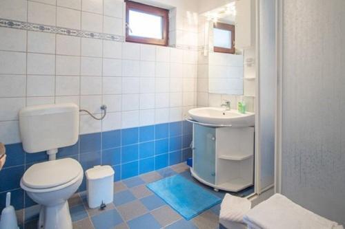 a bathroom with a toilet and a sink at Apartment and Rooms Luka in Vrbnik