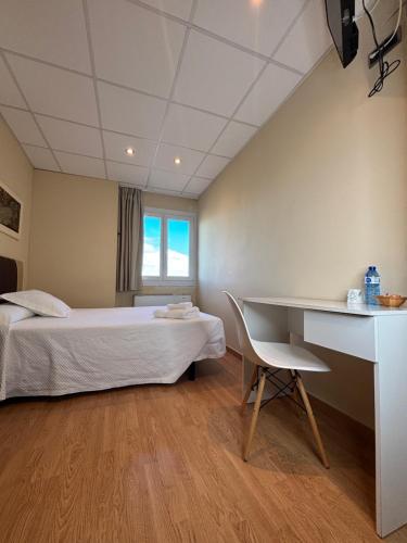 a hotel room with a bed and a desk at Hotel Restaurante El Colono in Gallur