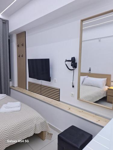 a bedroom with a mirror and a tv on the wall at AS luxury apartment in Athens