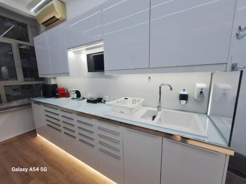 a white kitchen with a sink and a refrigerator at AS luxury apartment in Athens