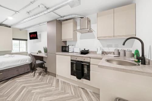 a kitchen with a sink and a bed in a room at The Lister Gate Studios in Nottingham