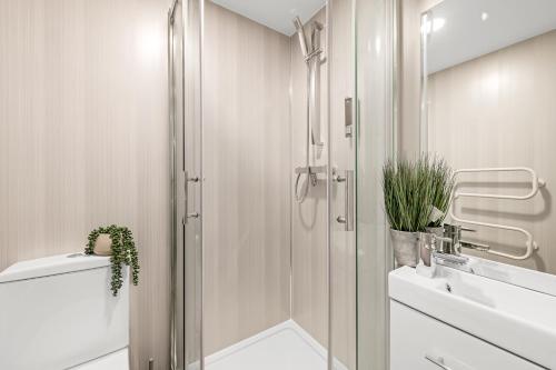 a white bathroom with a shower and a sink at The Lister Gate Studios in Nottingham