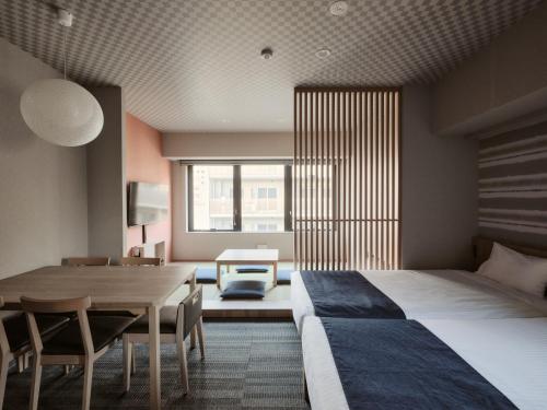a bedroom with a bed and a table and a dining room at MONday Apart Premium Ginza Shintomicho in Tokyo