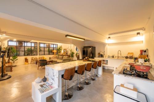 a large kitchen with a counter and a living room at Rwanda Naziza - Private Villa in the Old Town City - PRIME LOCATION I Daily Housekeeping in Chiang Mai