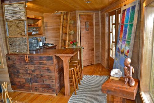 a kitchen with a wooden island in a log cabin at La Casa Del Árbol De Chiloé in Castro
