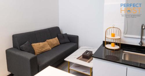 a living room with a couch in a kitchen at Neu Suites @ 3rdNvenue by Perfect Host in Kuala Lumpur