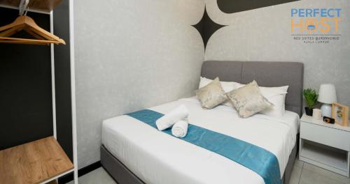 a bedroom with a white bed with pillows on it at Neu Suites @ 3rdNvenue by Perfect Host in Kuala Lumpur
