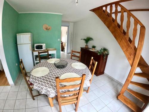 une salle à manger avec une table et un escalier dans l'établissement Maison Barneville Plage, à Barneville-Carteret