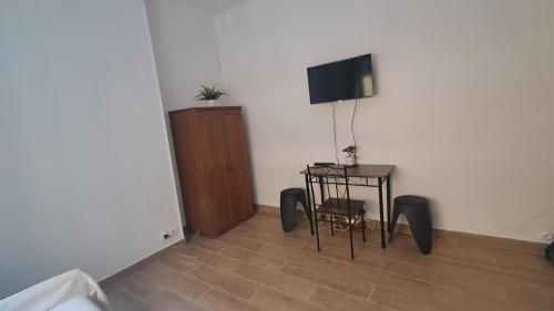 Cette chambre dispose d'une télévision, d'une table et d'une chaise. dans l'établissement Studio au cœur du vieux port, à Marseille