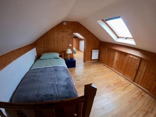 une chambre avec un grand lit dans un grenier dans l'établissement Maison Barneville Plage, à Barneville-Carteret