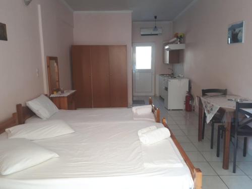 Un dormitorio con dos camas y una cocina con mesa. en Geni Bay 2, en Lefkada