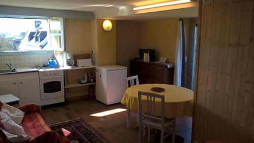 une cuisine avec une table et une petite cuisine avec une table et des chaises dans l'établissement Studio vue mer, à Plomodiern