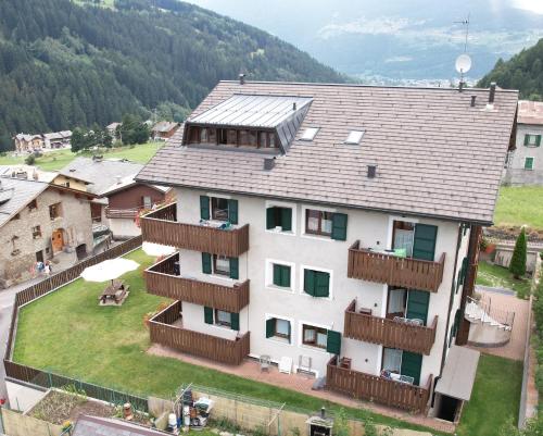 a large white building with a balcony and a house at Residence Casa Federica in Valfurva