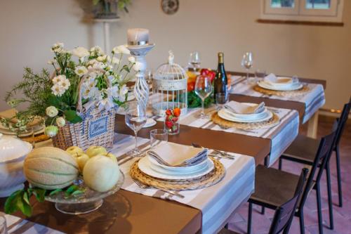 a dining room table with plates and glasses and flowers at Villa Papari in Montecarlo