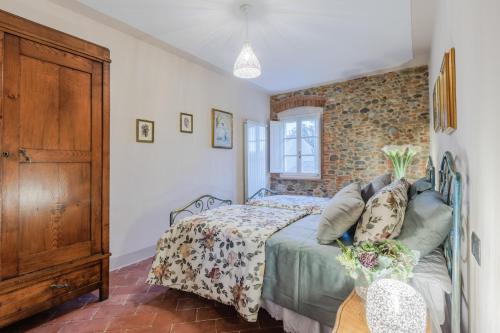 a bedroom with a bed and a brick wall at Villa Papari in Montecarlo