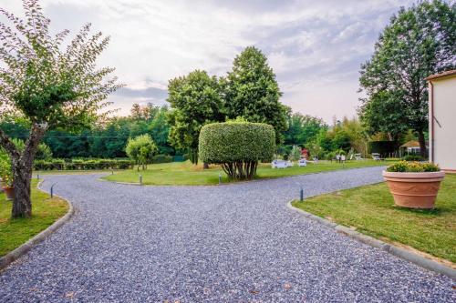 a gravel driveway with two large pots on the sides at Villa Papari in Montecarlo