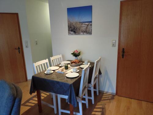 a dining room table with a blue table cloth and chairs at Ferienhof Lüke in Wesselburener Deichhausen