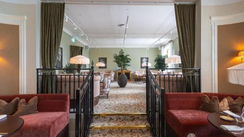a hotel lobby with red couches and a waiting room at Maryhill Estate in Glumslöv