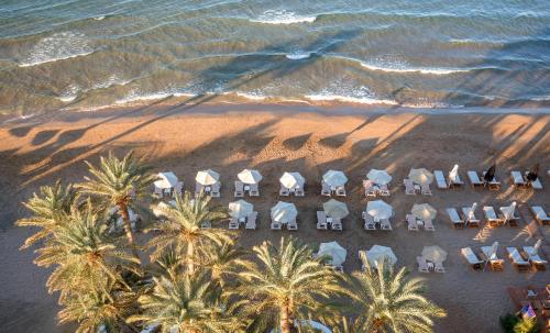 an aerial view of a beach with chairs and palm trees at Zeus Hotels Palm Beach in Stalís