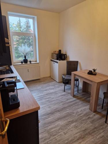 an office with a desk and a table and a window at Helle 3 Zimmer Wohnung im Harz in Halberstadt