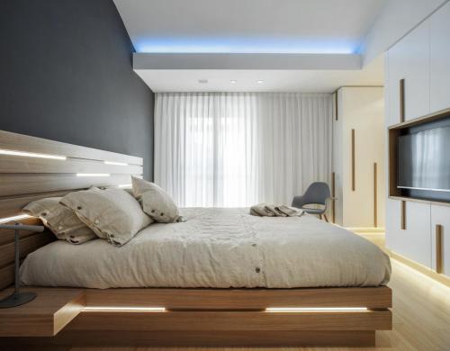 1 dormitorio con 1 cama y TV en Canticle Lucca Luxury Apartment, en Lucca