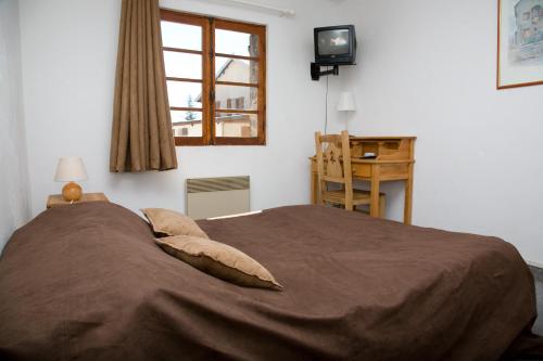 a bedroom with a large bed and a window at Adonis Le Chastellan in Valberg