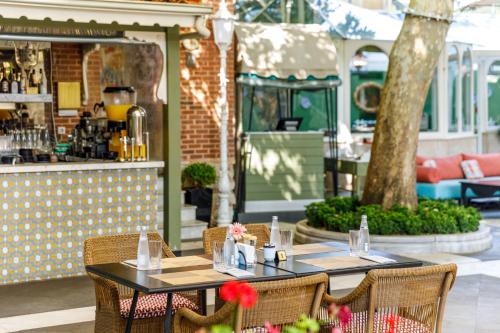 two tables and chairs in front of a restaurant at Hagia Sofia Mansions Istanbul, Curio Collection by Hilton in Istanbul
