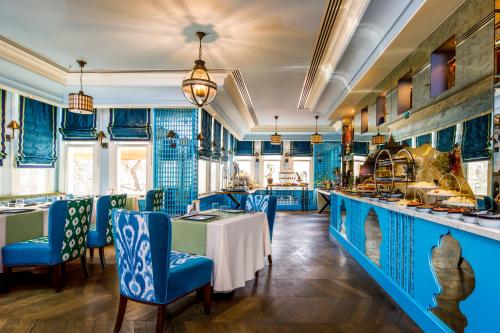 a restaurant with blue walls and tables and chairs at Hagia Sofia Mansions Istanbul, Curio Collection by Hilton in Istanbul