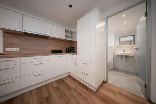 a kitchen with white cabinets and a sink at Pension Pitze in Sölden