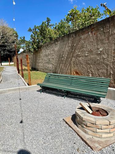 a green park bench sitting next to a wall at Dona Nilza Hotel Fazenda in Brasilia