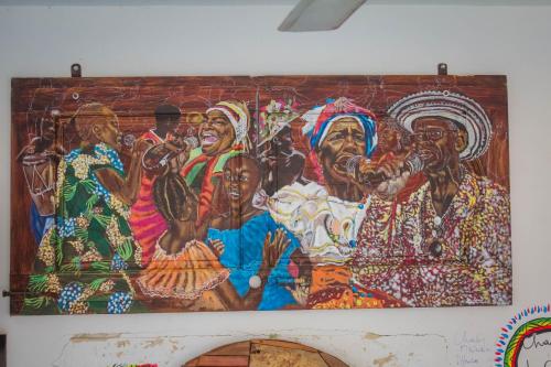 a painting of a group of people on a wall at Hotel - Granja de Animales San Basilio de Palenque in San Basilio del Palenque