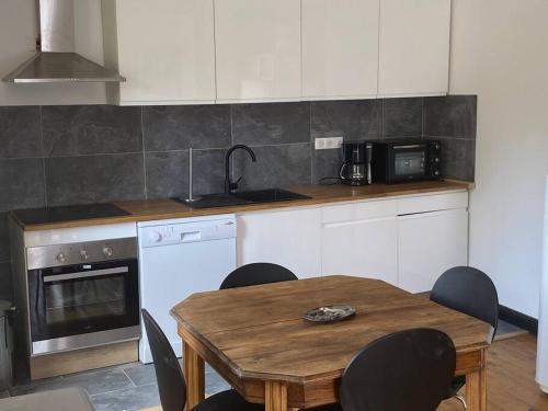 une cuisine avec une table en bois et une table et des chaises dans l'établissement Duplex au village Bolquere-Pyrénées 2000 ski-été, à Bolquère-Pyrénées 2000