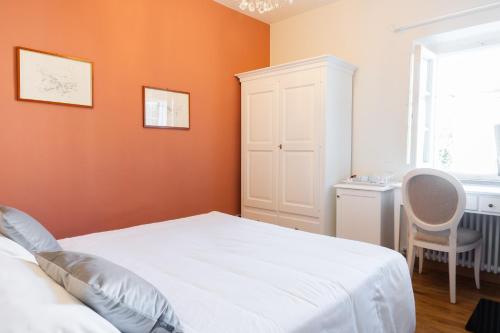 a bedroom with orange walls and a white bed at B&B Ninfeo dell' Arancera in Calci