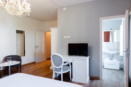 a bedroom with a bed and a desk with a television at B&B Ninfeo dell' Arancera in Calci