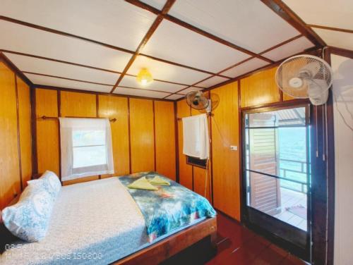 a small bedroom with a bed and a window at Tao Thong Villa 2 in Ko Tao