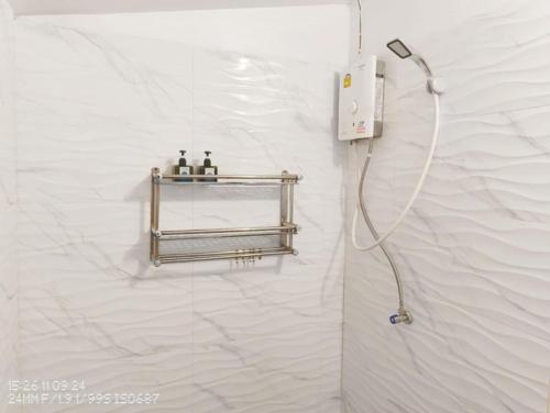 a shower in a bathroom with a white wall at Tao Thong Villa 2 in Ko Tao