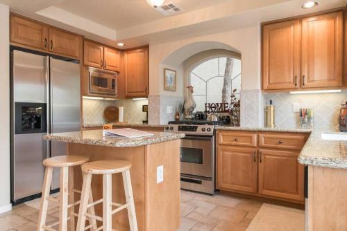 a kitchen with wooden cabinets and stainless steel appliances at Elegant beautiful home With Pool & Heated Spa in Las Vegas