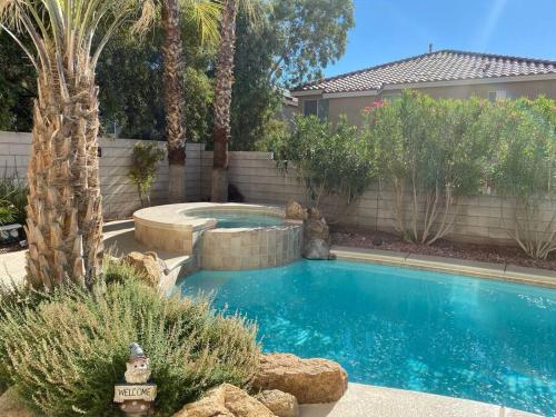 a swimming pool in a yard with a palm tree at Elegant beautiful home With Pool & Heated Spa in Las Vegas