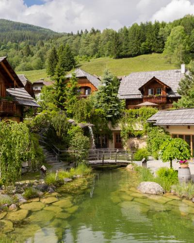 a village with a bridge over a river at st martin chalets in Sankt Michael im Lungau
