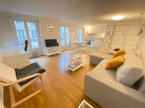 un salon avec un canapé et une table dans l'établissement L'auberge des Halles- Epuré & confortable, à Paris