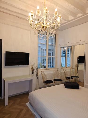 une chambre avec un grand lit et un lustre dans l'établissement Paris Montorgueil Seng, à Paris