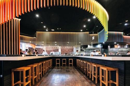 a restaurant with a long bar with wooden stools at The 2 Bedroom Hurstville Haven in Sydney