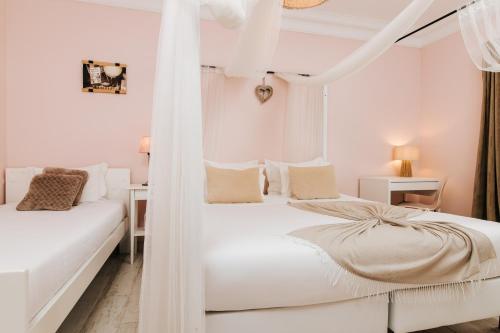 2 camas en un dormitorio blanco con cortinas blancas en Boutique Hotel - O House Ericeira Hills, en Ericeira